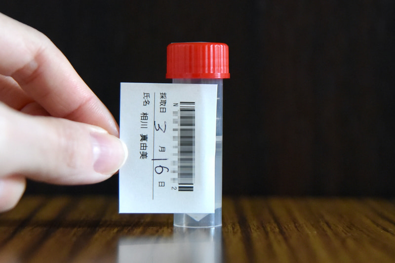 本人確認用の名前とバーコード入りのシールを容器に貼る。採取日の記入も忘れずに