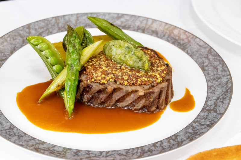 メインディッシュは、和牛フィレ肉のグリル（140g）に神戸ワインとマスタード・九条ネギのコンディメント、ホワイトワインとフォンドヴォーを使ったソースで提供