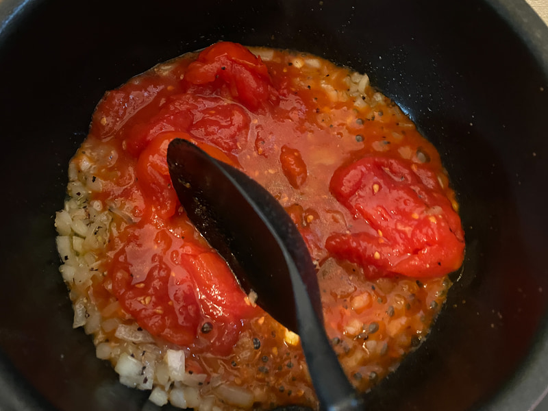 ホールトマト、オレガノを入れて、トマトを潰しながら炒め煮にします
