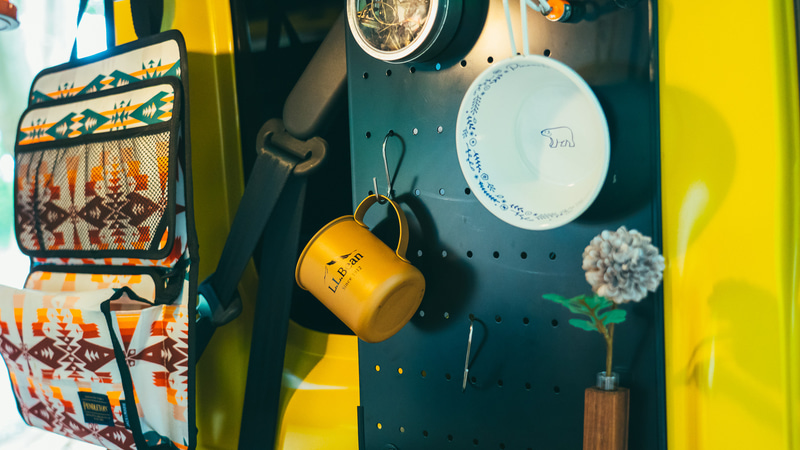 車内の「有孔ボード」はマグネットが付くので、磁石つきの小物入れにヘアゴムを入れたり、S字フックをかけてコップ置きにしたり