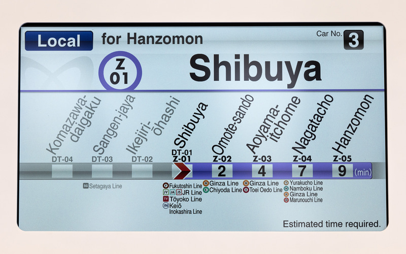 右側画面に次駅や行き先、号車、乗換案内などを多言語で表示。左画面には広告などが表示される
