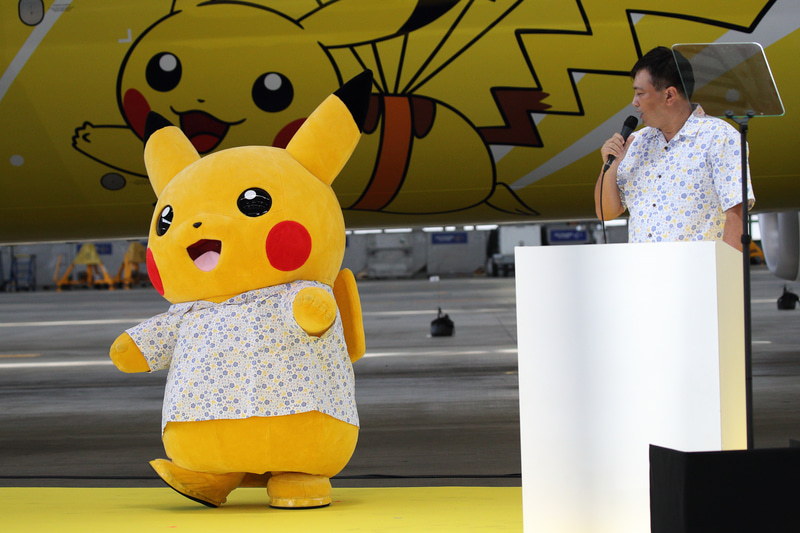 かしゆりウェアを着たピカチュウと新プロジェクトの詳細を紹介した株式会社 執行役員 福永晋氏