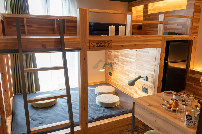 ステイコンセプトルームは木造2段ベッドを窓際に配置し、壁面の有孔ボードにそれぞれのテーマに合った備品をディスプレイしている