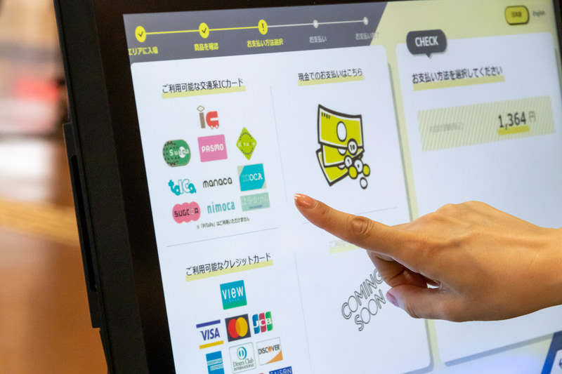 ゲートをくぐり、購入したい商品を手に取り、レジでセルフ会計をするだけなので、非常にスピーディに購入できる。レジは日本語のほか、英語表記にも対応している。なお、正確な記録をするために店内は10人までの入場制限がある