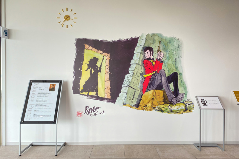 町役場内の壁にあったイラスト。2018年に亡くなった原作者のモンキー・パンチさんに感謝する言葉が添えられていました