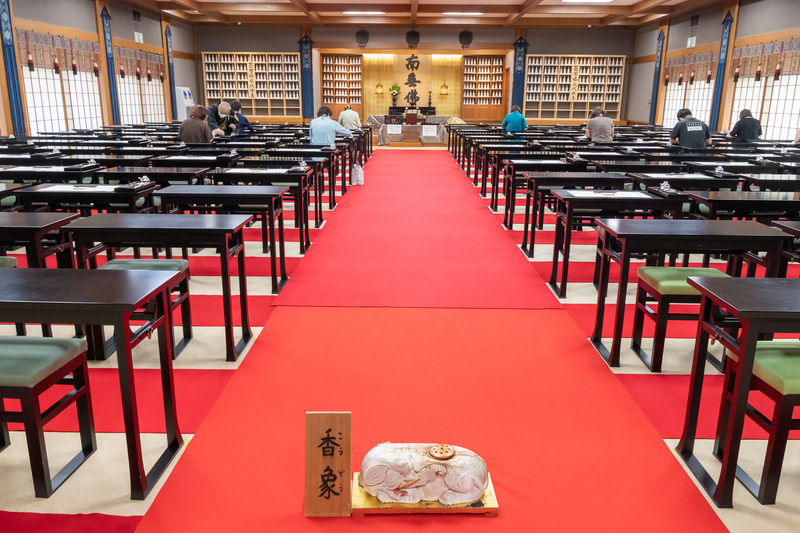 一度に180名までお写経できる道場。お香を焚いている香象をまたいで入る
