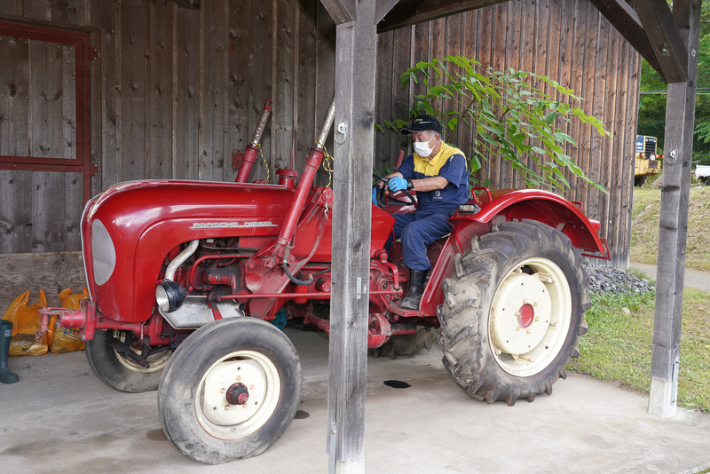 ポルシェのトラクターへ乗り込む池田さん