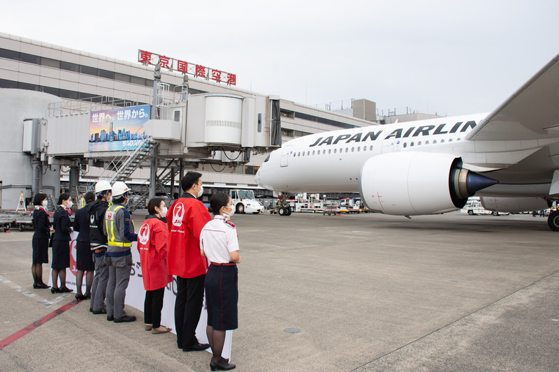 駐機場ではスタッフが横断幕で初便を見送った