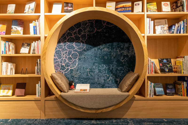 壁一面の本棚のなかにある丸いくり抜きスペースは館内一の映えスポット！ということで私も記念にパチリ
