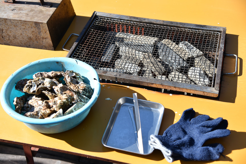 「焼き牡蠣1kg」と貸し出しされる手袋とナイフやトレイ一式