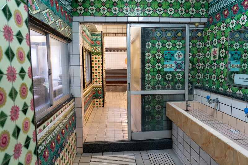 脱衣所から浴室へ続く通路には壁一面にマジョリカタイル。イギリスをルーツに持つマジョリカタイルは、日本では明治時代末以降さかんに生産されました