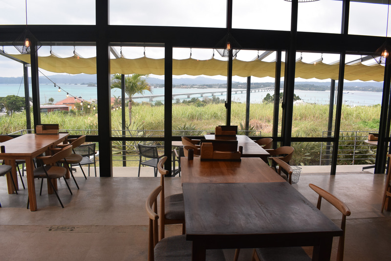 ガラス張りの店内からは、古宇利大橋と海を一望。テラス席もある