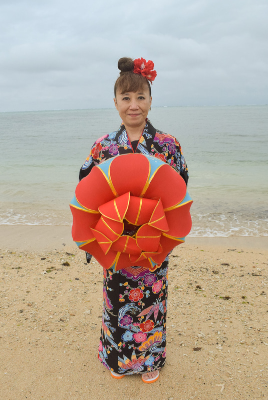 海辺での撮影。小道具として花笠を持たせてくれた