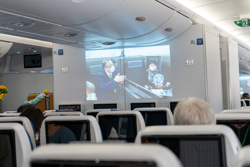 参加者はこのトークセッションを機内前方のモニターで鑑賞