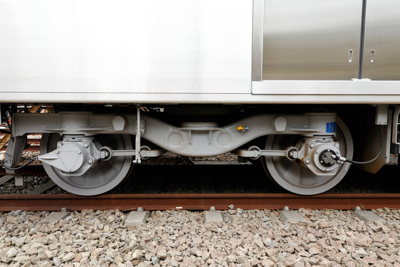 台車は一般的なボルスタレス台車。ブルーラインは第三軌条式といって、頭上に架線を設ける代わりに、線路脇に給電用のレールを設置する方式。そのため、一部の台車は給電用のレールに接触させる集電靴（コレクターシュー）を備えるが、先頭車の台車（写真）には付いていない。電圧は直流750V