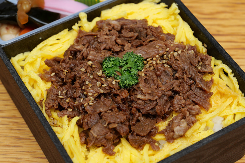 牛肉煮には米沢牛を使用。また牛肉の下には錦糸玉子も敷き詰められている