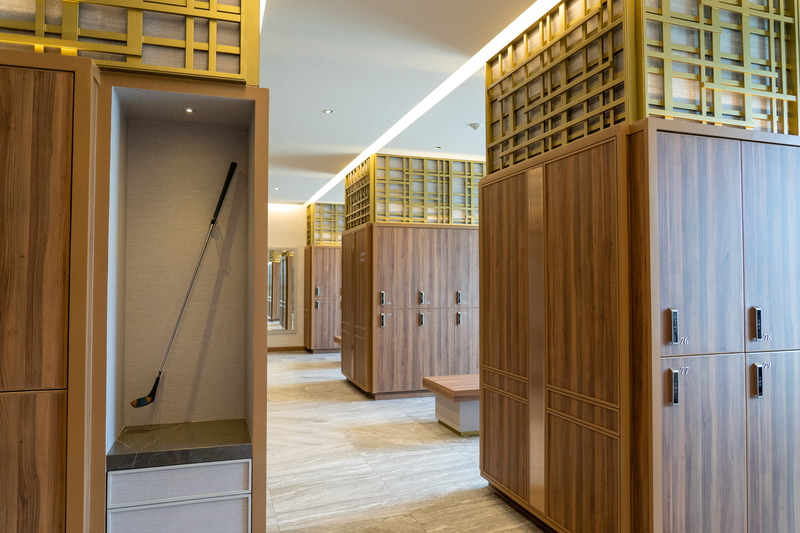 高級感ある木目調のロッカールーム（男性用）。洗面台もシャワーブースも広くてキレイ