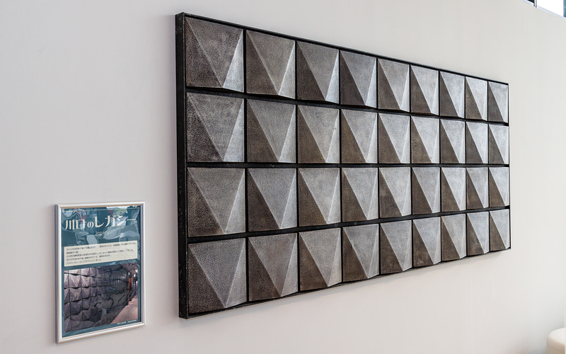 壁には川口市の旧市役所本庁舎手使われていた鋳物製の壁装飾の一部が移設されている