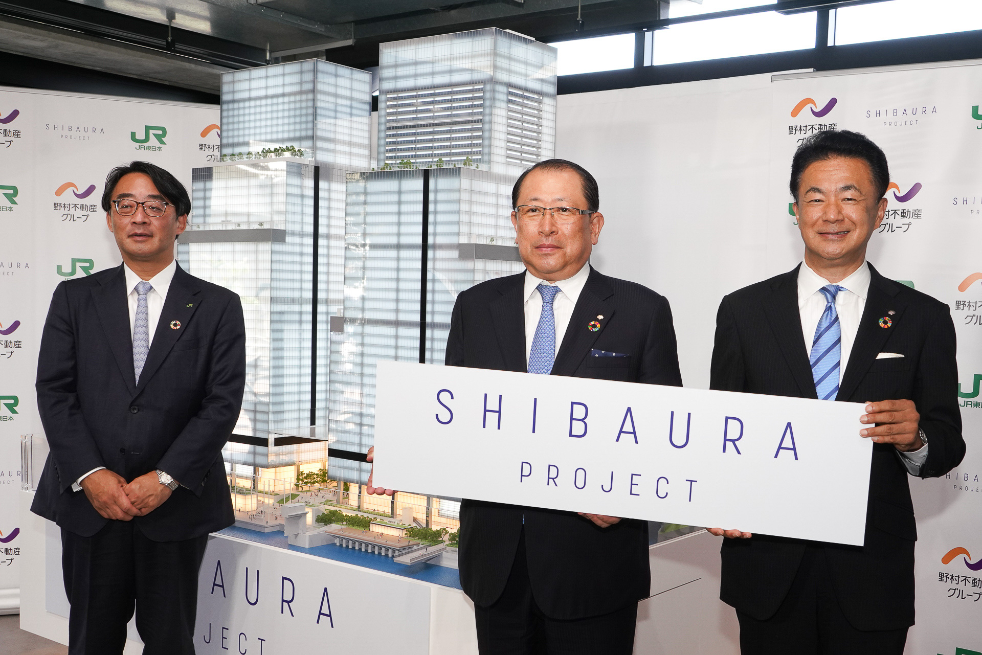 「芝浦プロジェクト」で建築する予定のビル模型。右から野村不動産ホールディングス株式会社 代表取締副社長 グループCOO 兼 野村不動産株式会社 代表取締役社長 松尾大作氏、野村不動産ホールディングス 代表取締役社長 兼 グループ CEO 沓掛英二氏、東日本旅客鉄道株式会社 代表取締役副社長 喜㔟陽一氏