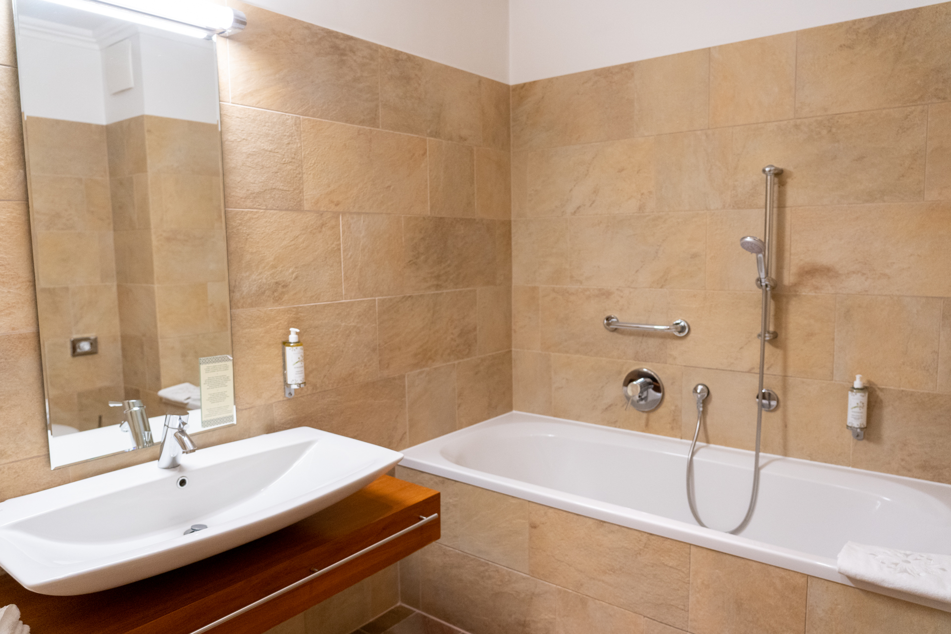 バスルームは大きなバスタブ付き。ホテルのロゴマークが刺繍されたバスマットが素敵