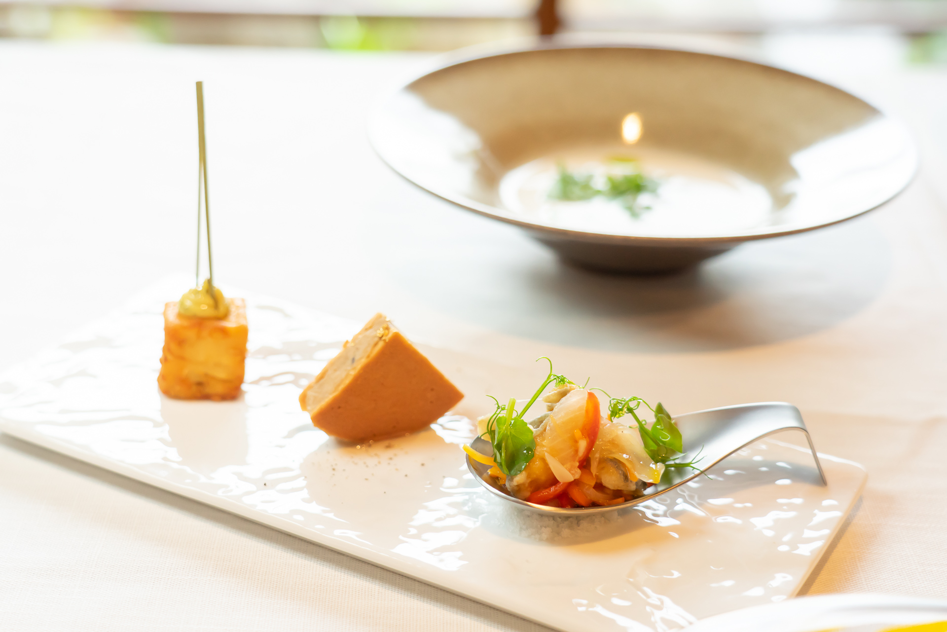 アミューズブーシュの盛り合わせ。手前から「秩父産ニジマスのエスカベーシュ」「武州豚のリエットと秩父産蜂蜜のクリスピーサンド」「借金無し大豆のファラフェルとハーブソース」。奥に「秩父しゃくし菜ヴィシソワーズ」