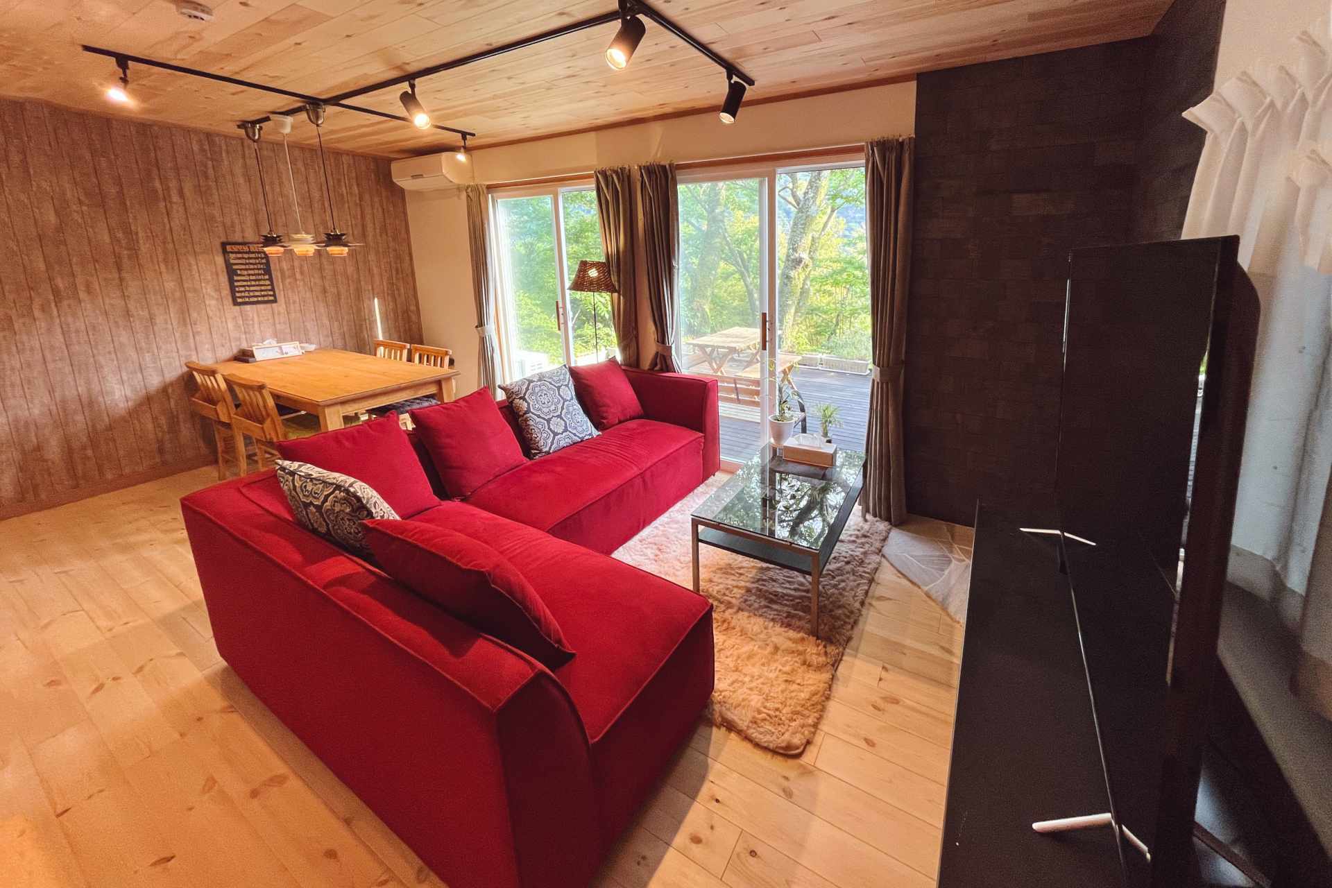 滞在のメインスペースとなるリビング・ダイニング・キッチンは、赤いソファが目を引くメリハリの利いたインテリア