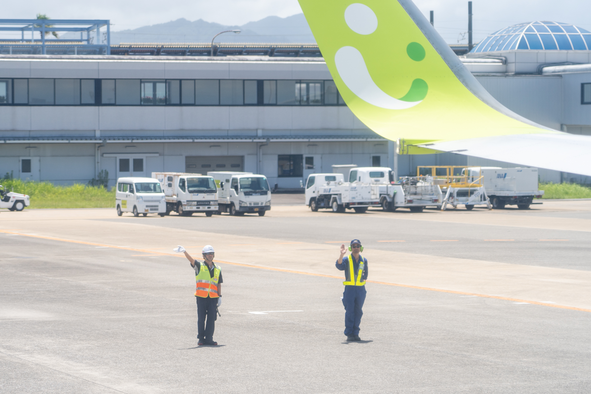 スカイネットアジア航空時代のネイビーのつなぎを着用の整備士さん（右）