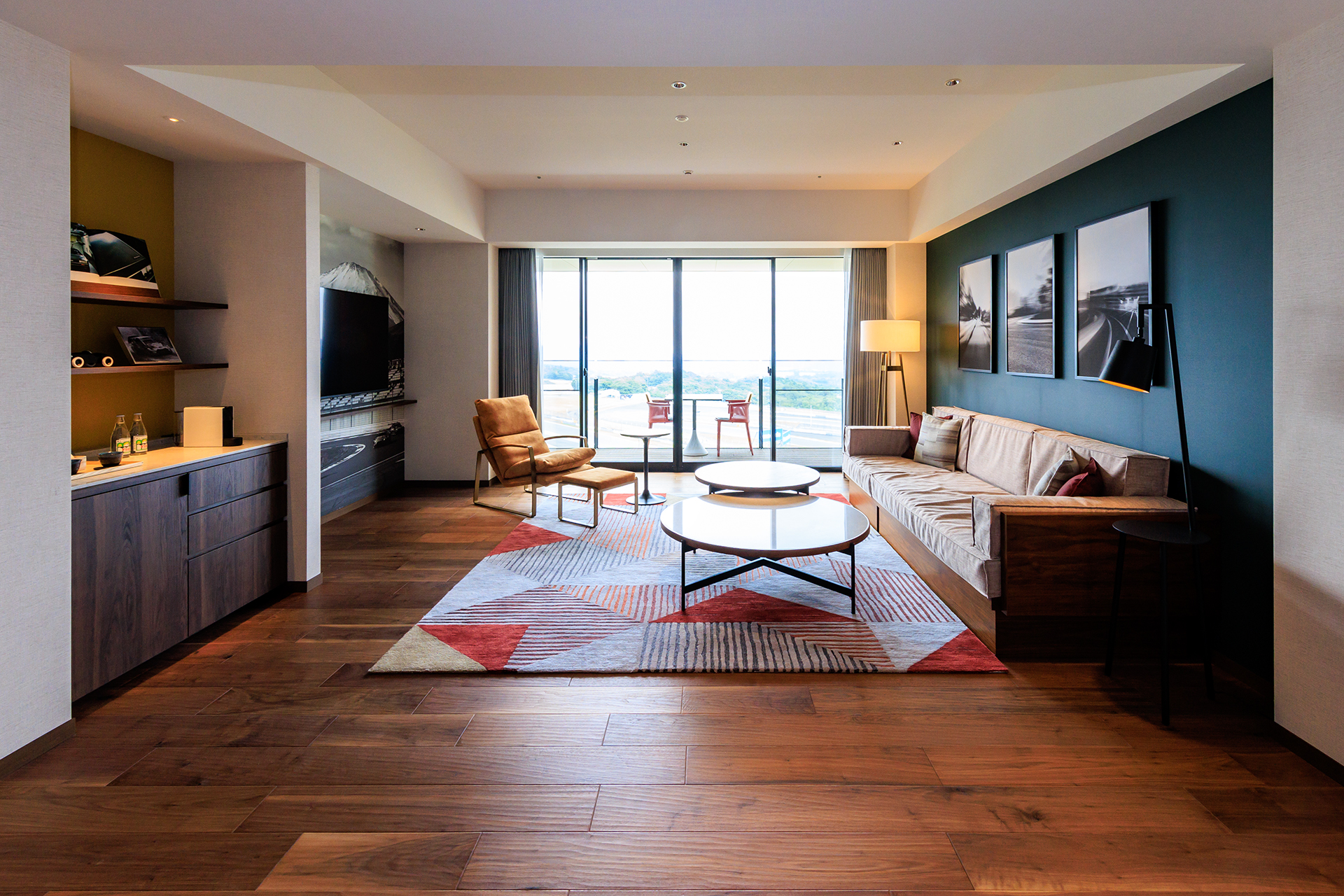 大型の液晶テレビやモータースポーツをモチーフとした絵画のあるリビングルーム