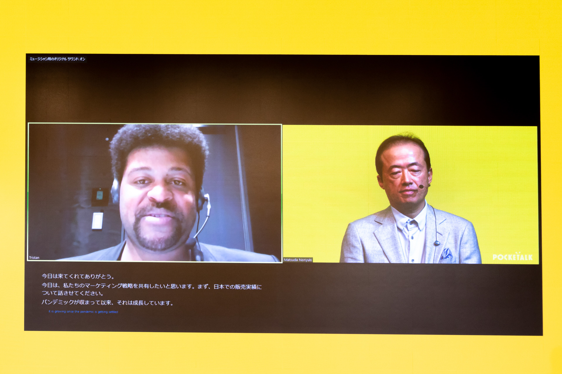 デモンストレーションの様子。外国人男性が英語で話すと字幕が表示され、翻訳した内容を日本語の音声として出力する