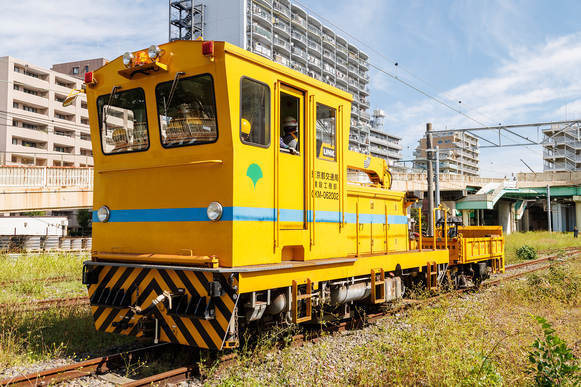 脱線復旧を行なう職員と、資材を積載したモーターカーが現場に到着