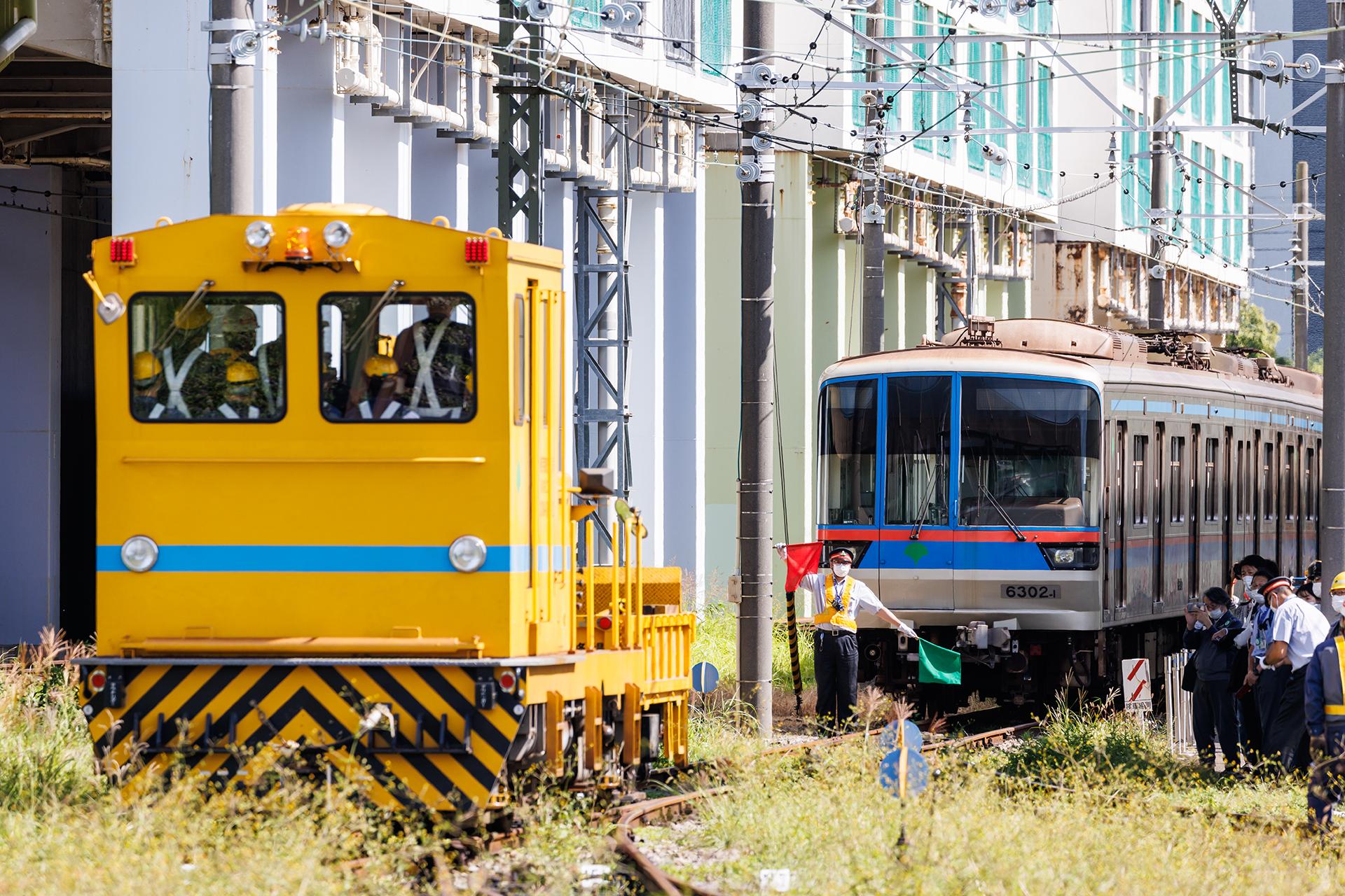 脱線復旧を行なう職員と、資材を積載したモーターカーが現場に到着