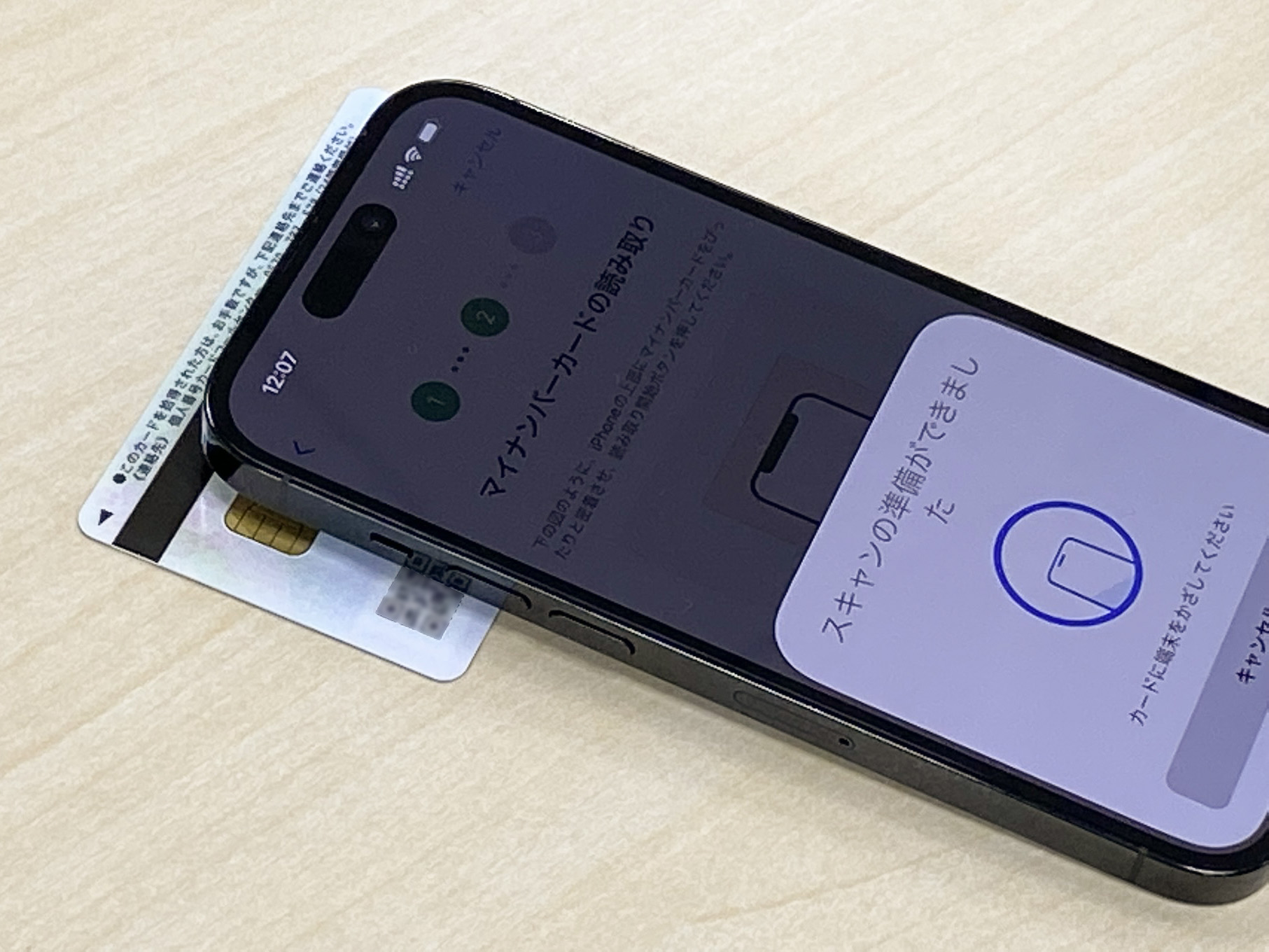 スマートフォンの背面にカードを置いて読み取りを行なう