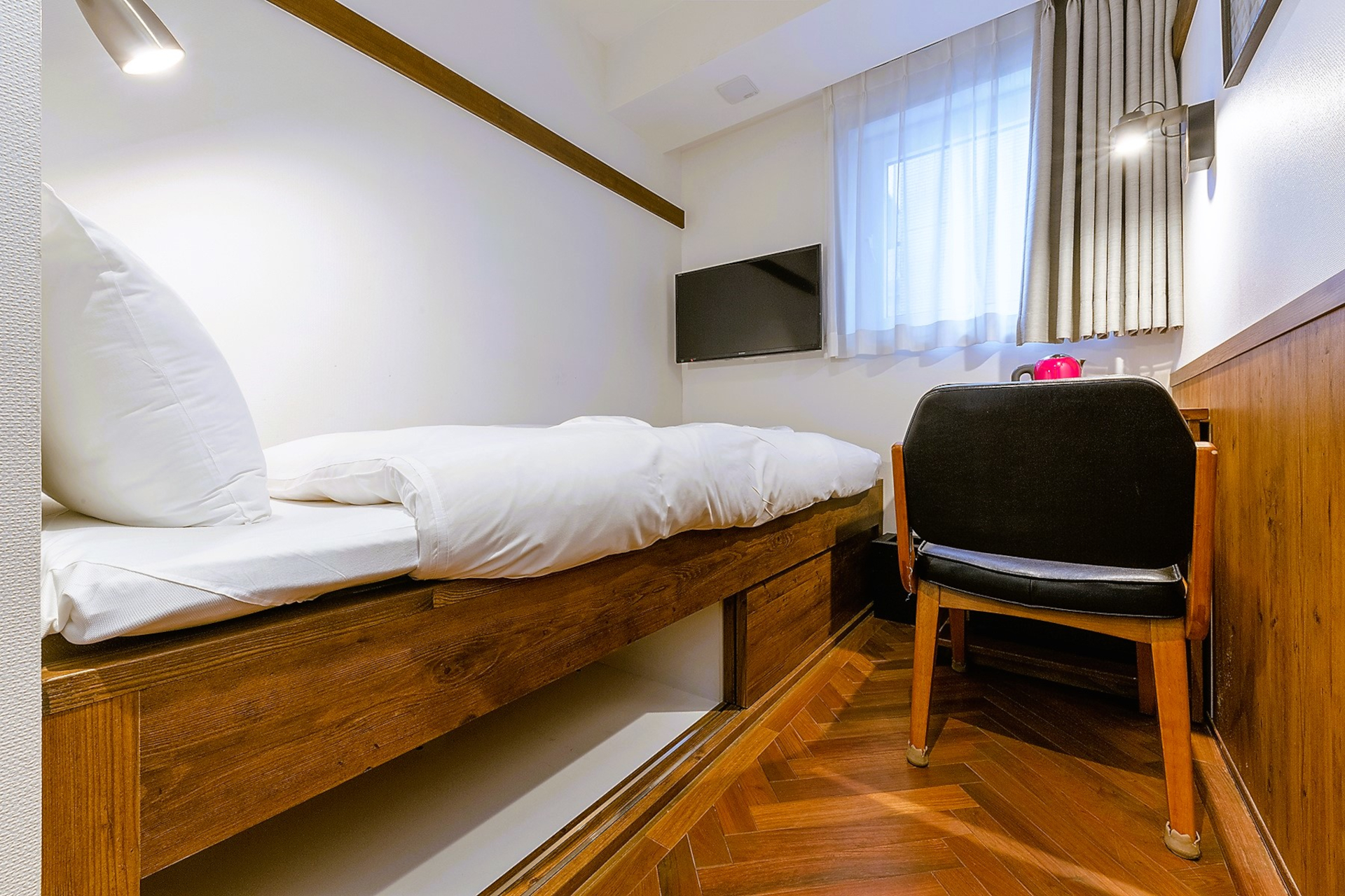 フローリング和室（シングル）は靴で過ごせる寄木張りの床。小上がりに布団を敷いている