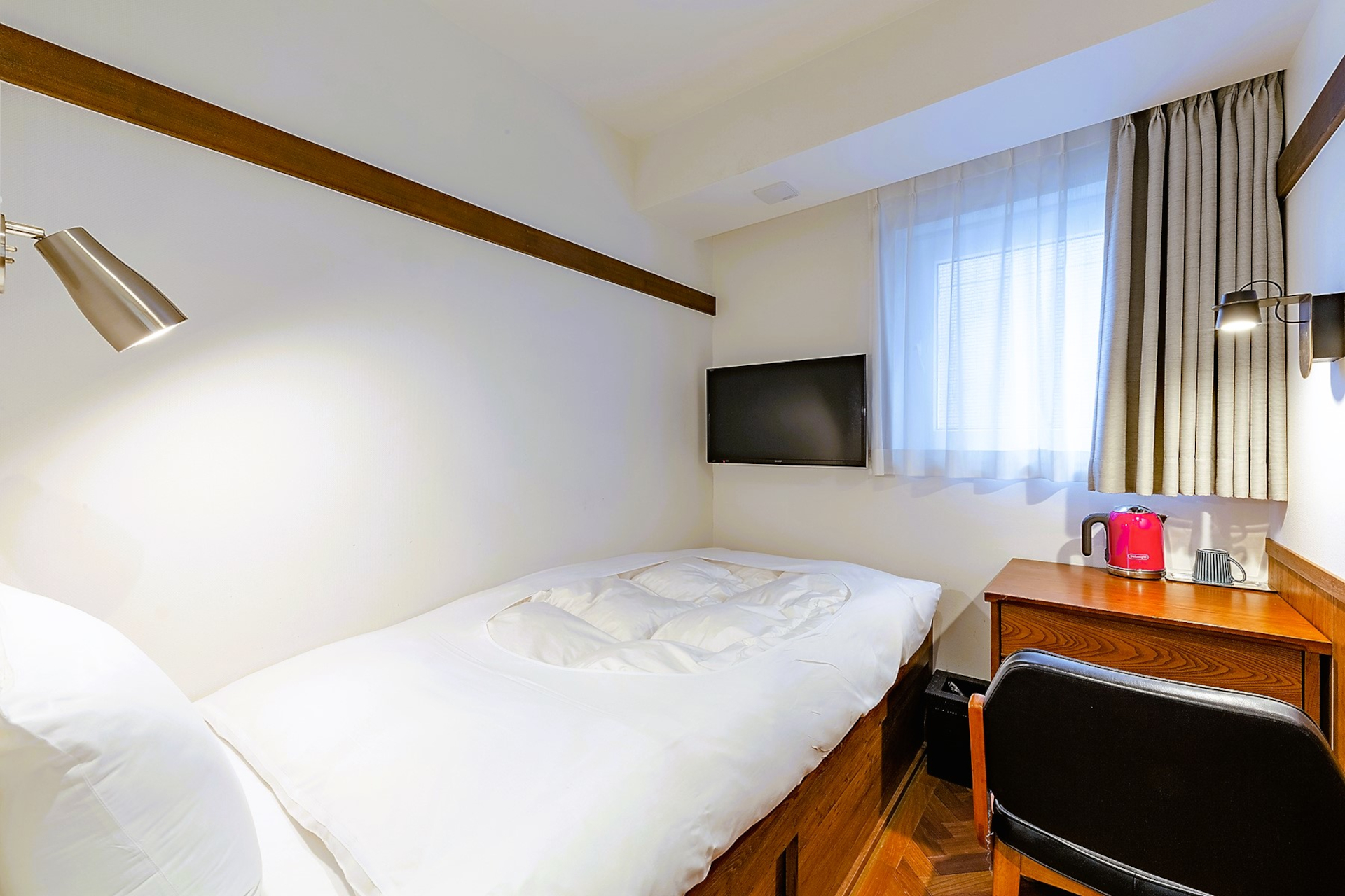 フローリング和室（シングル）は靴で過ごせる寄木張りの床。小上がりに布団を敷いている