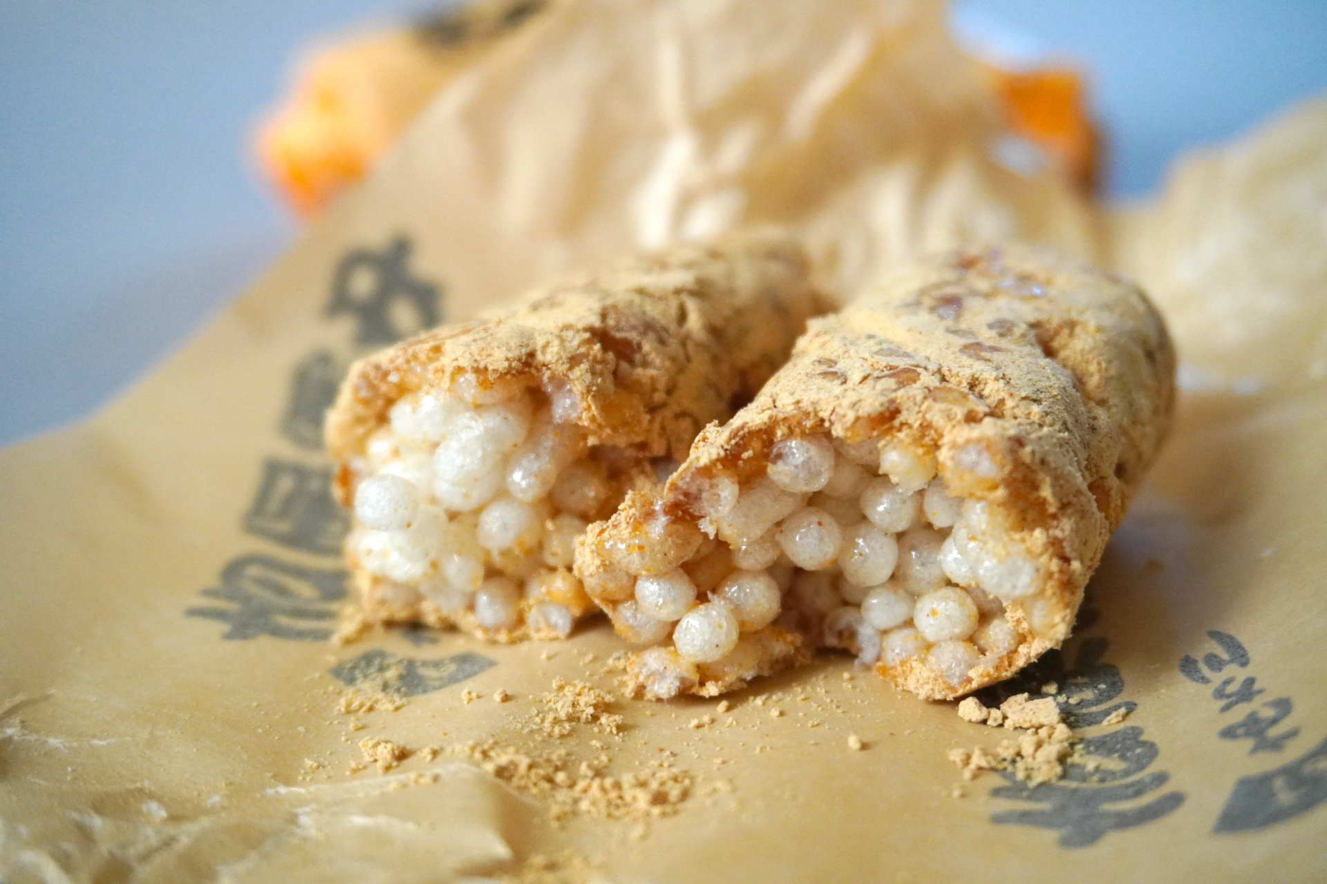 紙で包まれた棒状の吉原殿中。割ってみると、水あめが糸を引いて納豆みたいです