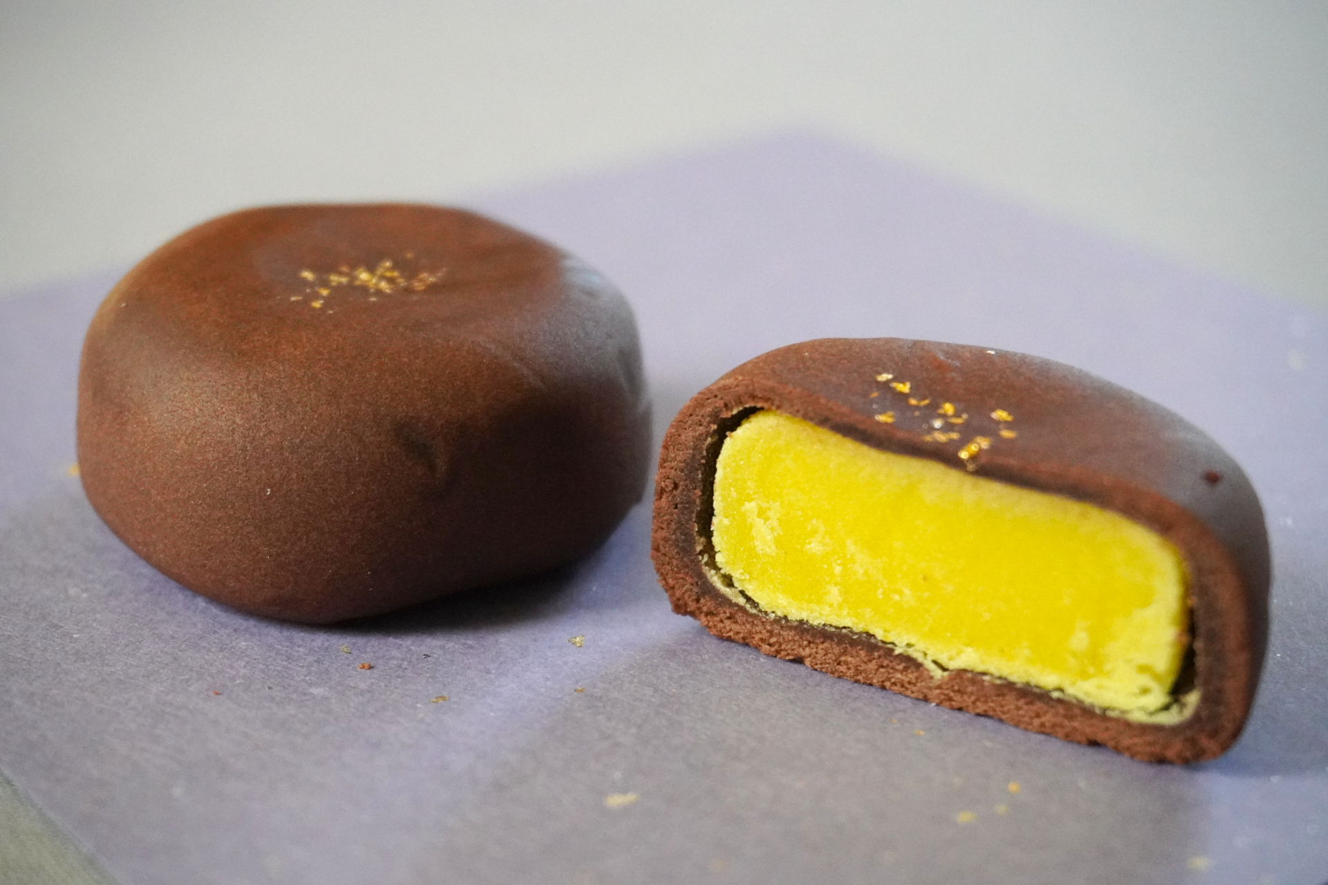 ぎっしり詰まった黄味餡が満月を思わせる「天満月」。光沢のあるチョコレート皮にふりかけた金粉は、夜空にきらめく星のよう