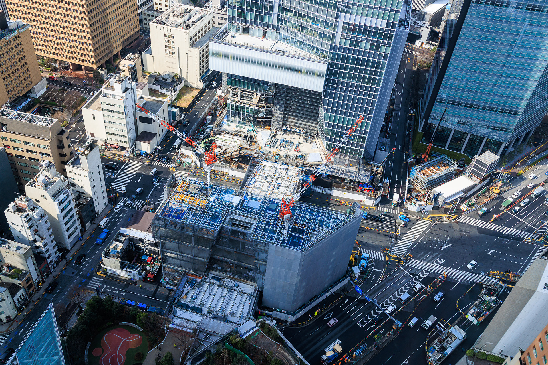 手前から森タワー、グロスロック、ステーションタワー。中央を横切っているのが国道1号線で、その上に幅員20mの大規模歩行者デッキ「T-デッキ」が整備される。国道1号線の地下に虎ノ門ヒルズ駅がある