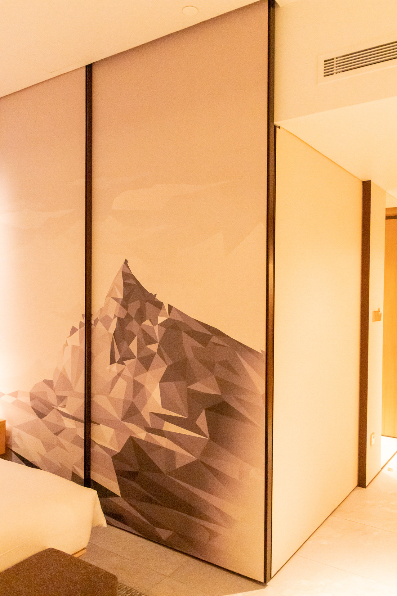 襖のような可動式の壁。キナバル山のアートを楽しむのもよいし、収納して部屋を広く見せてもよい。遊び心のあるギミックは楽しい