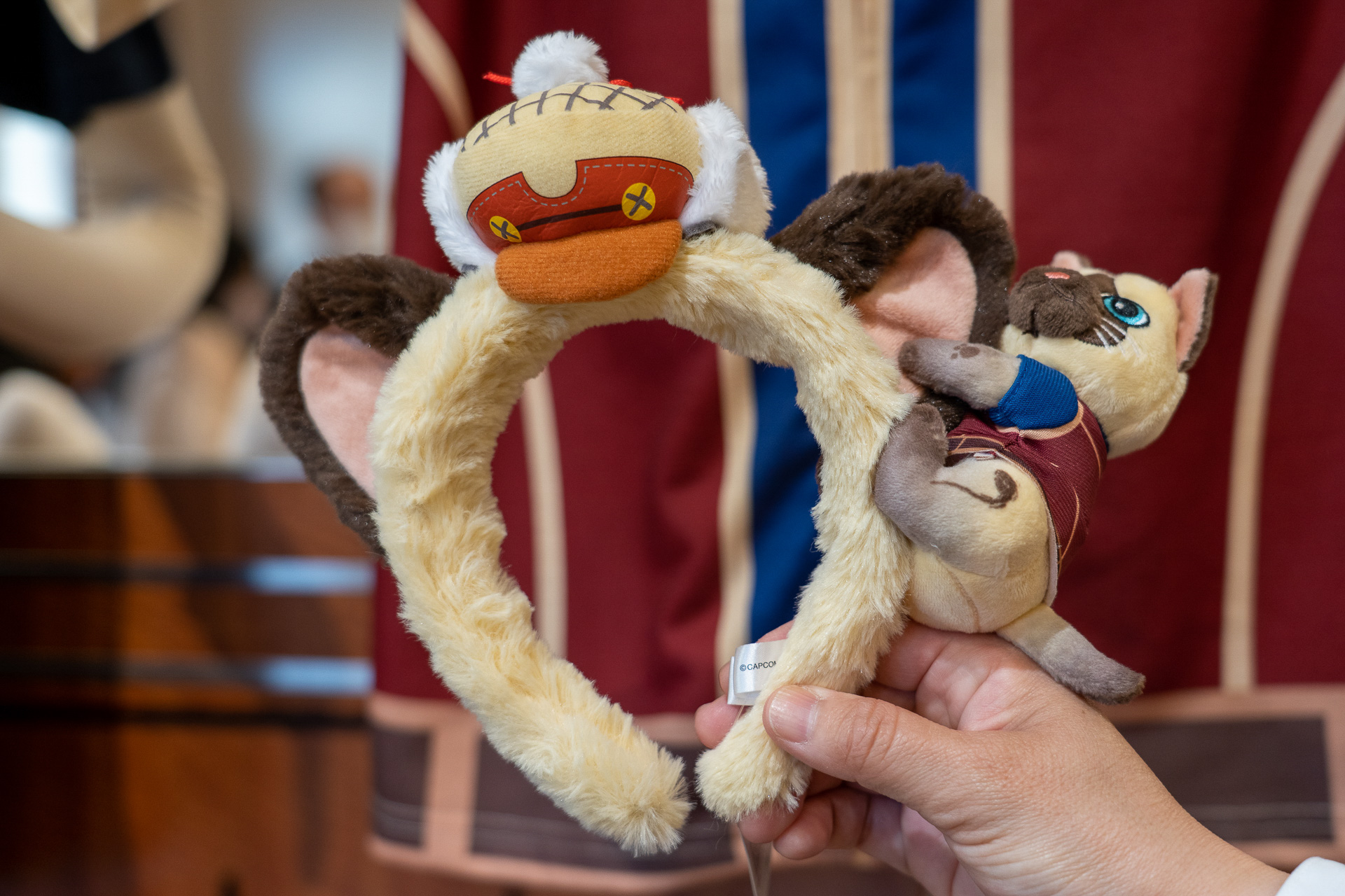 耳にしがみついているのは小さいアイルー。人気のコラボカチューシャは2800円