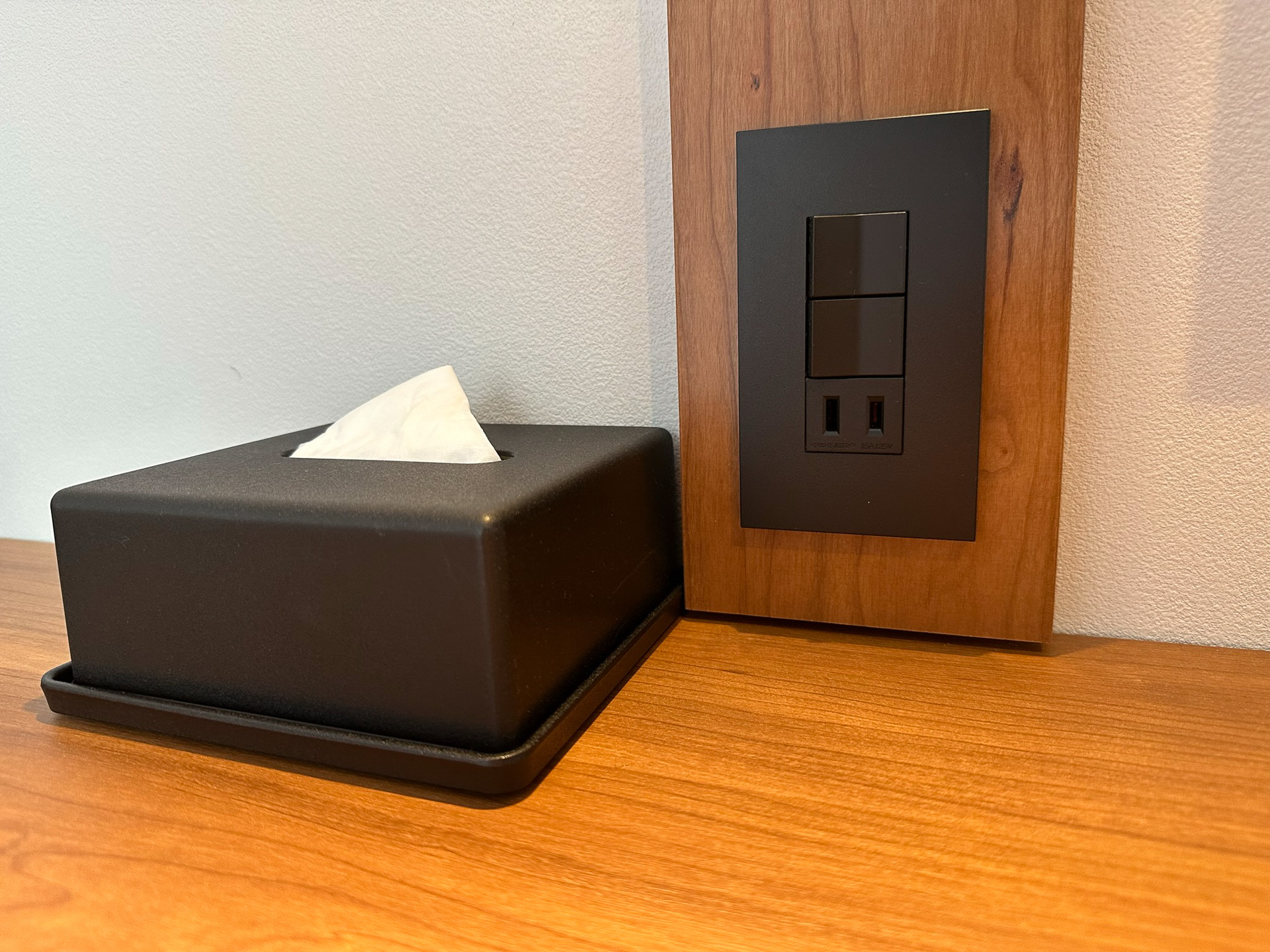 ティッシュケースやコンセント・スイッチパネルも黒で統一。デスクのコンセントは1口だが、すぐ近くにベッド脇のコンセントがあるので問題ない