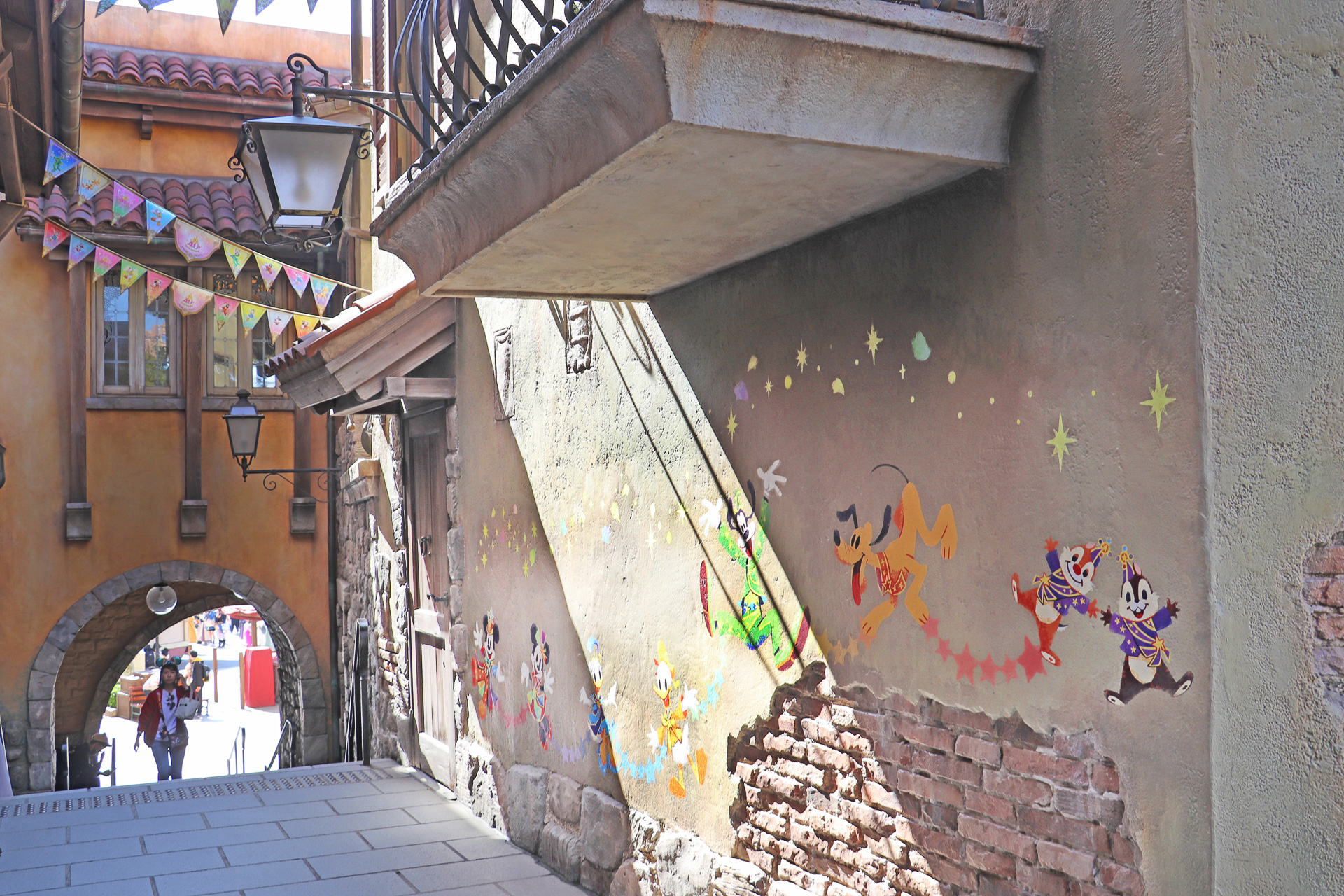 イル・ポスティーノ・ステーショナリーを回り込む細い路地に登場したガーランドと壁面のキャラクターたち