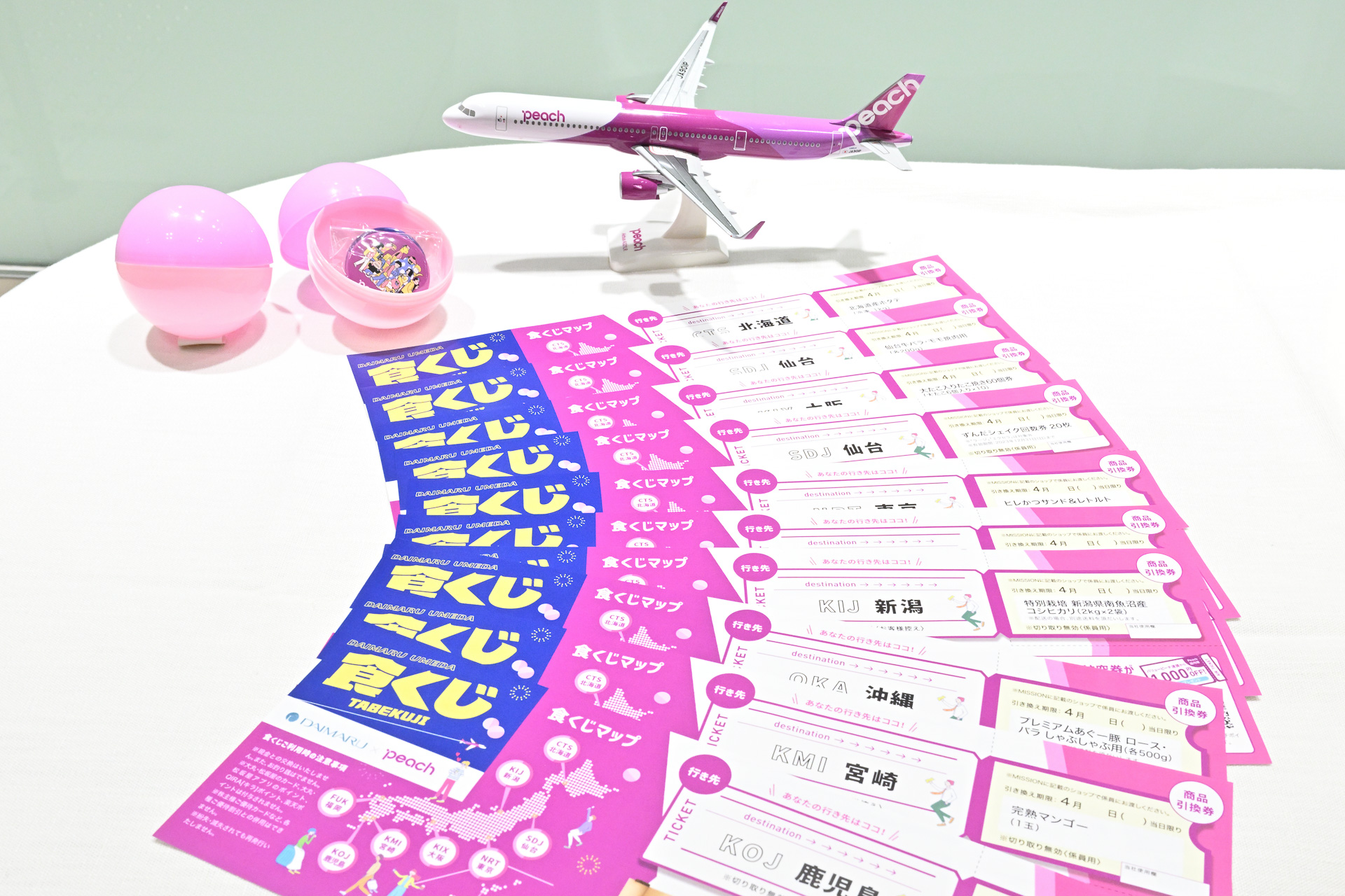 ピンクのカプセルには9つの就航地グルメ10種類のいずれかとの交換できるくじが封入されている