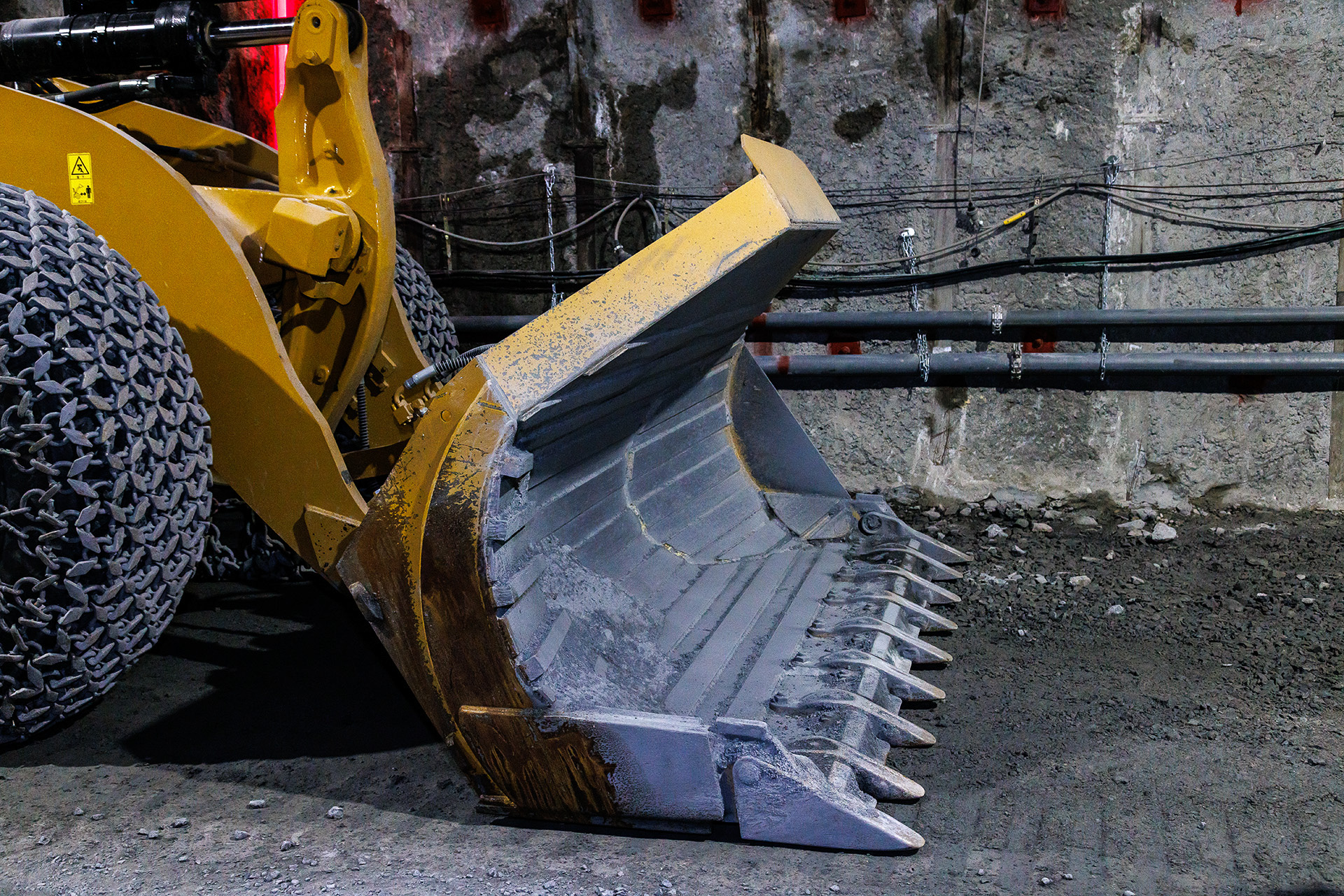 幅が狭いトンネル内での作業となるため掬ったズリはバケットを右に傾けて（写真手前側）ダンプに積載する。そのためサイドが切り取られた独特の形状をしている