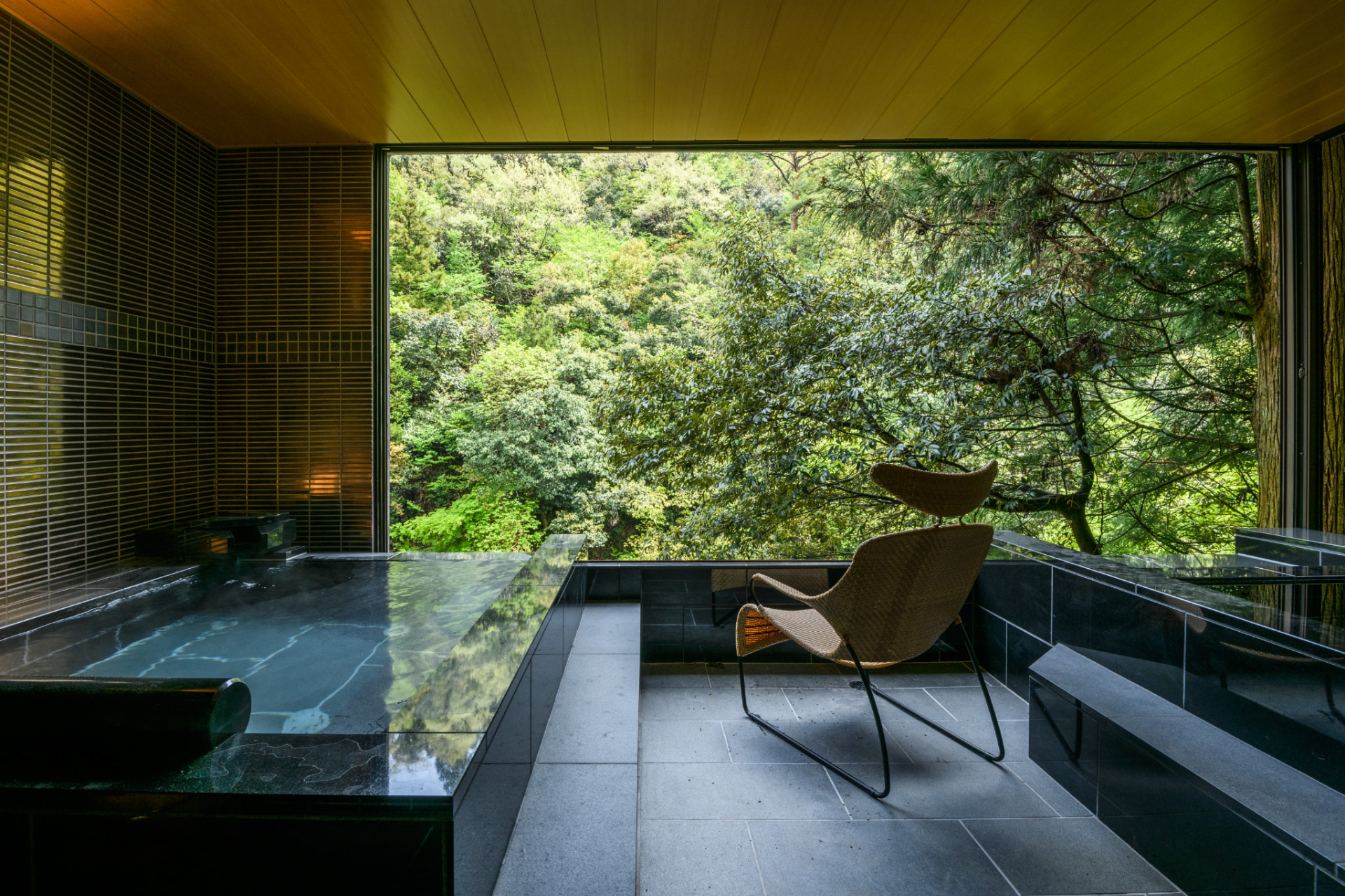 渓流沿いのテラスにテーブルとチェアを設置した「源泉露天風呂付特別洋室」