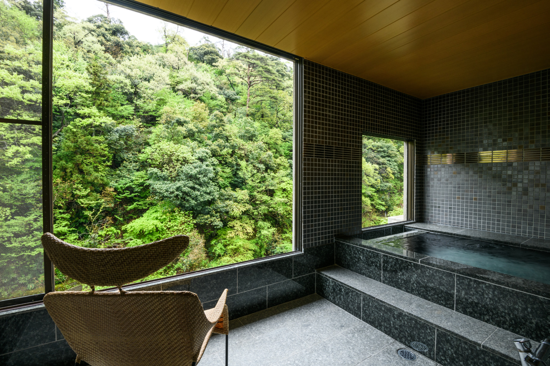 渓流沿いのテラスにテーブルとチェアを設置した「源泉露天風呂付特別洋室」