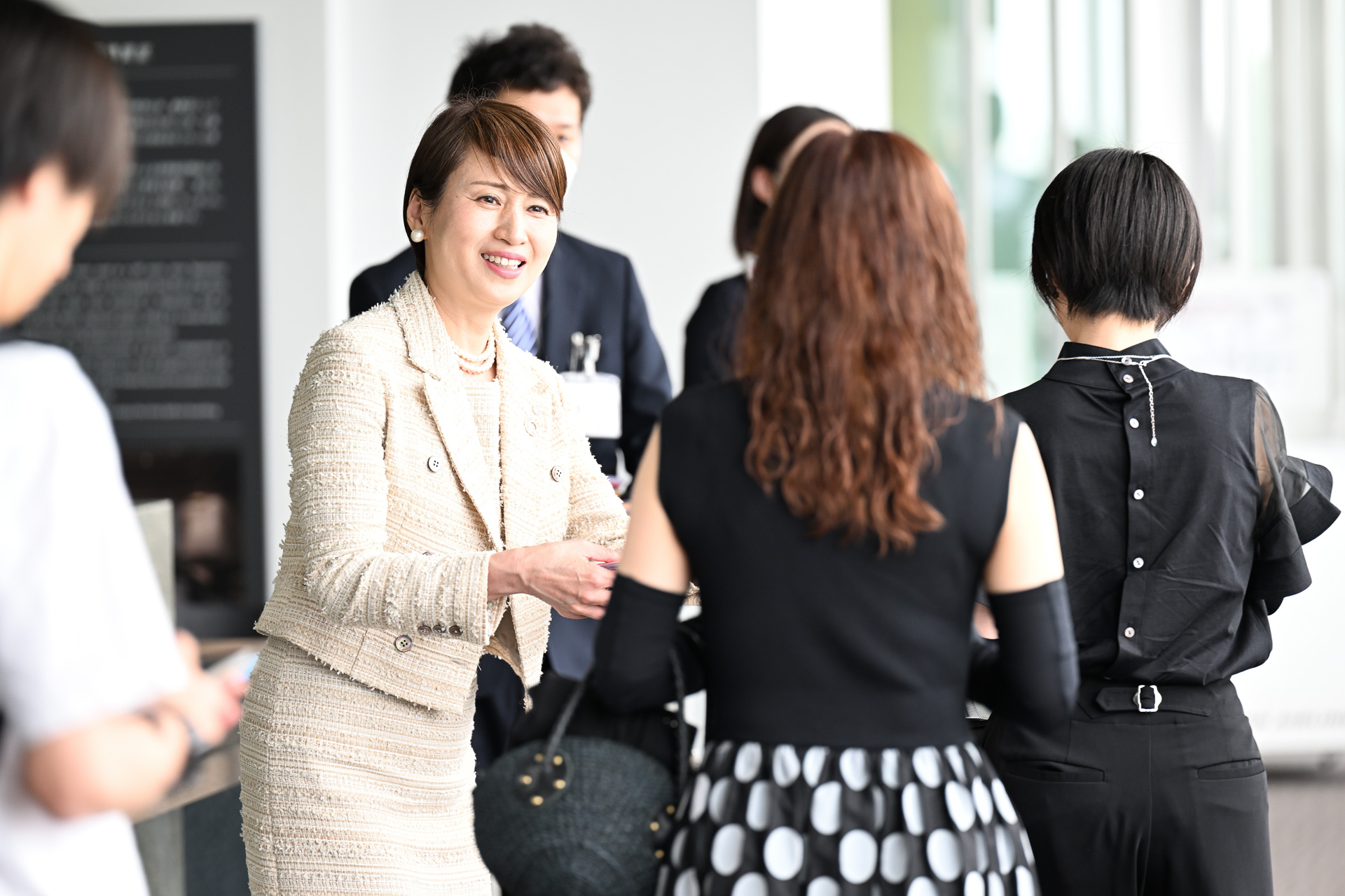 JAL羽田便の搭乗客に記念のフライトタグキーホルダーを手渡す日本航空株式会社 西日本支社長 宮坂久美子氏