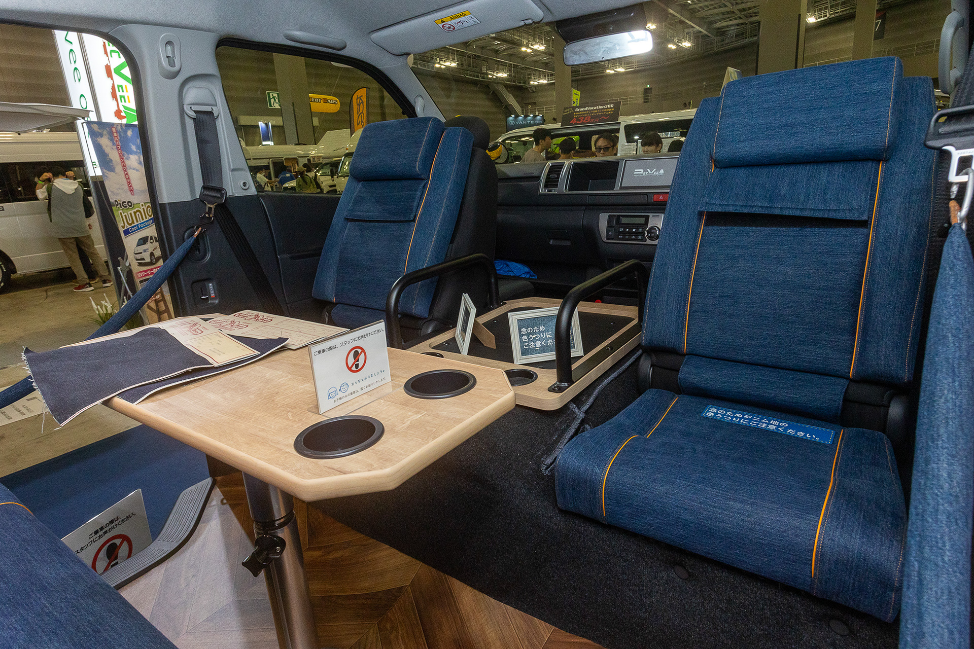 デニム調の生地を使ったインテエリアが特徴。バンライフ向けなので作りはあえてシンプルにしている。2列目のシートの足元にテーブルが付き、前席の背もたれを前倒し、クッションをあわせることで後ろ向きの座席を作り出している