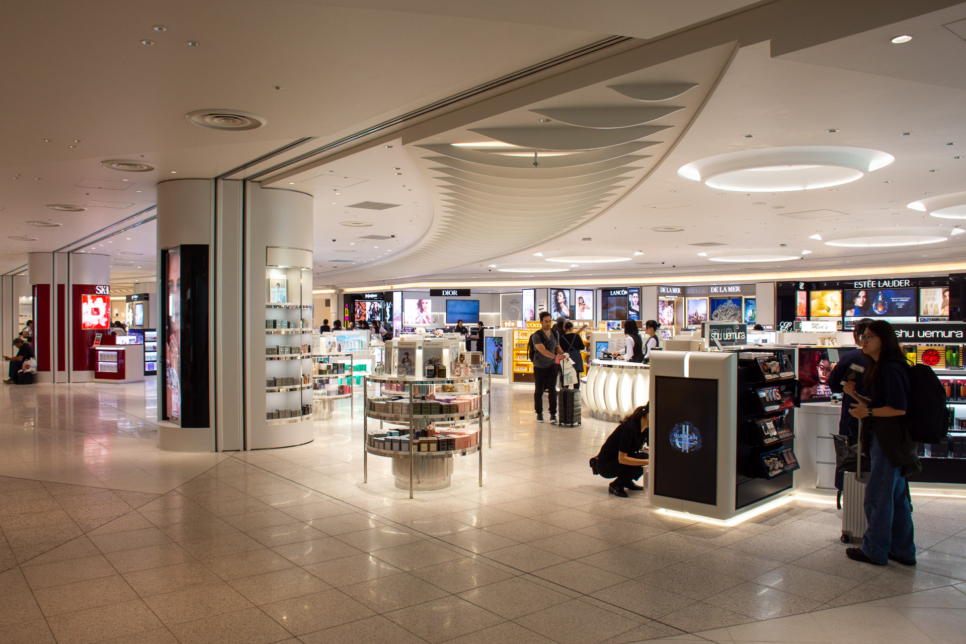 サイネージの先のスロープを下ると免税店が並ぶ