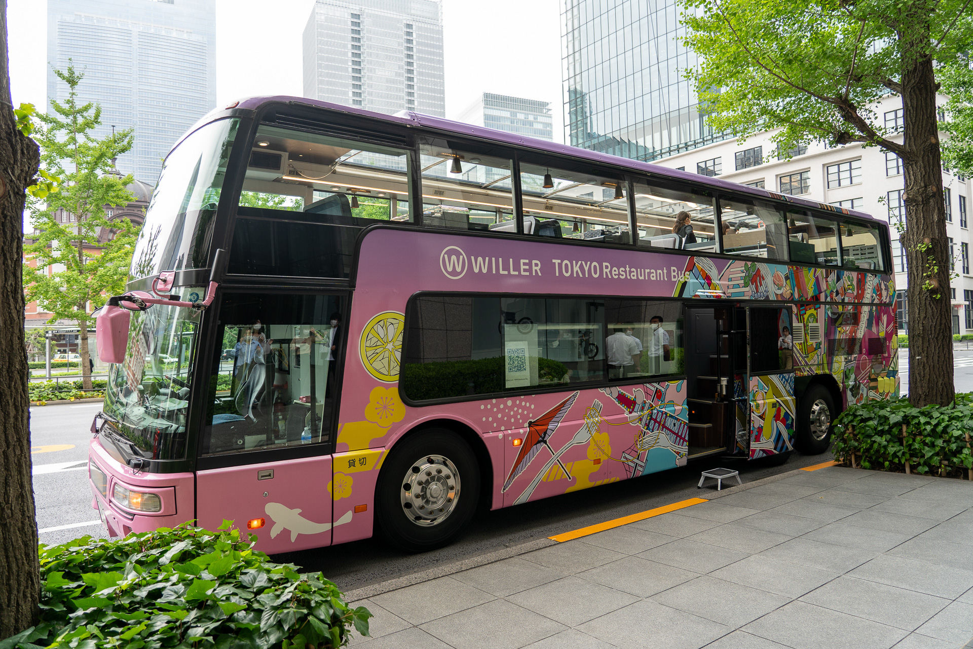 発着場所の東京駅 丸の内ビル前に停車する東京レストランバス。カラフルなイラストが描かれている2階建てバスだ