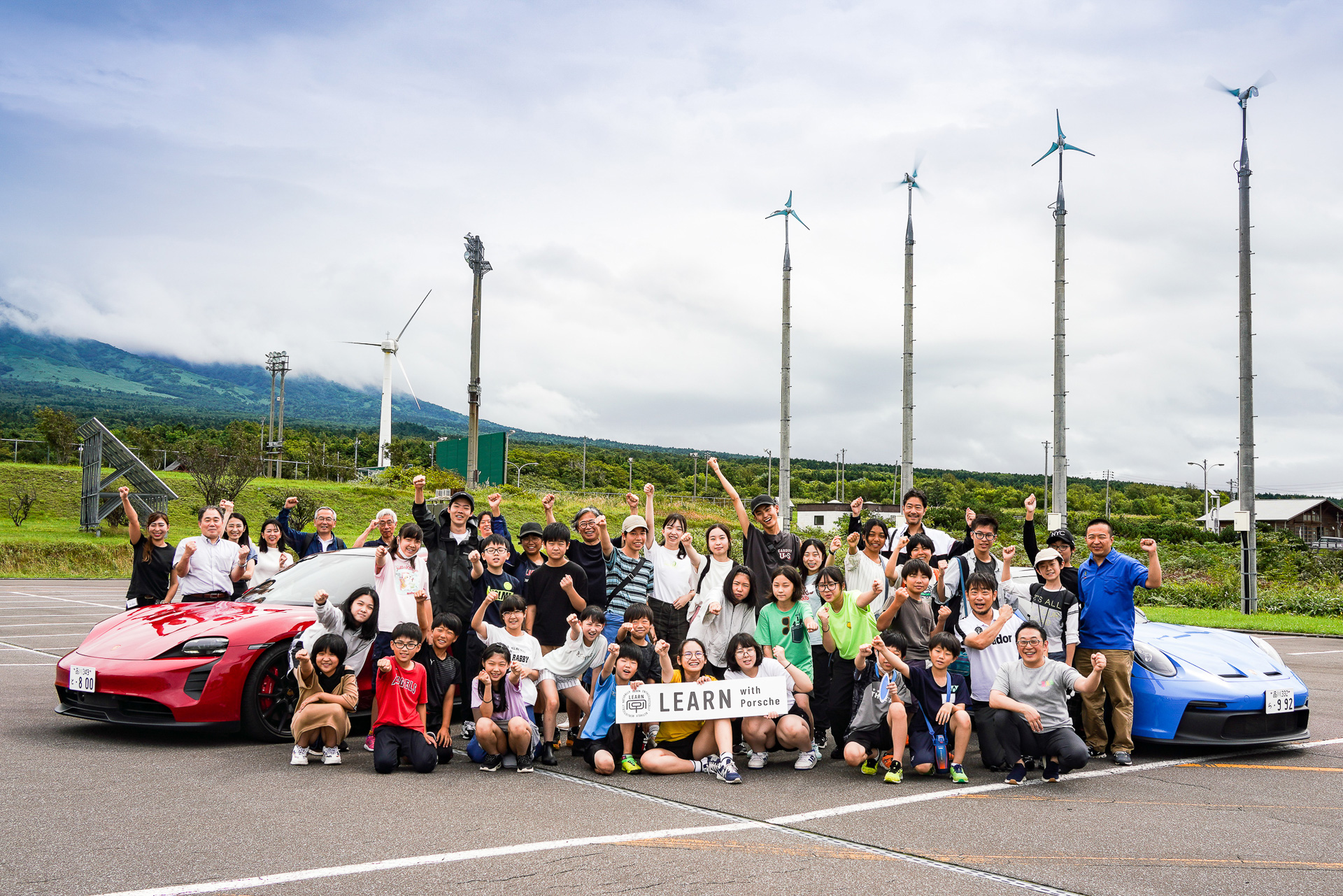「LEARN with Porsche 2023」の参加メンバーと利尻島の小学生たち。利尻町総合体育館 夢交流館にて